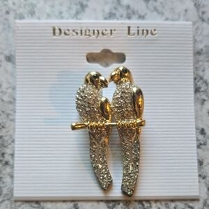 Vintage gold parrot brooch with rhinestone accents on body in emerald eyes
